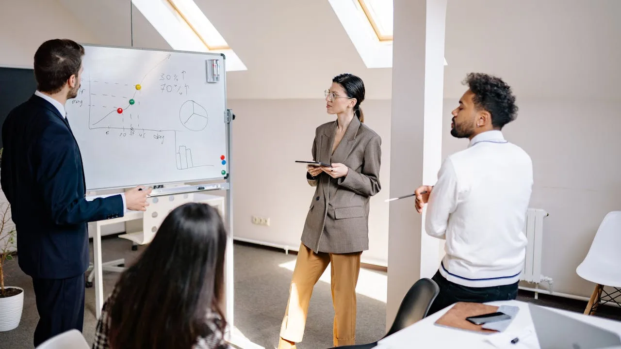 Enterprise team and embedded AI engineer collaborating on deployment strategy in modern office — forward deployed engineering model for brand leaders
