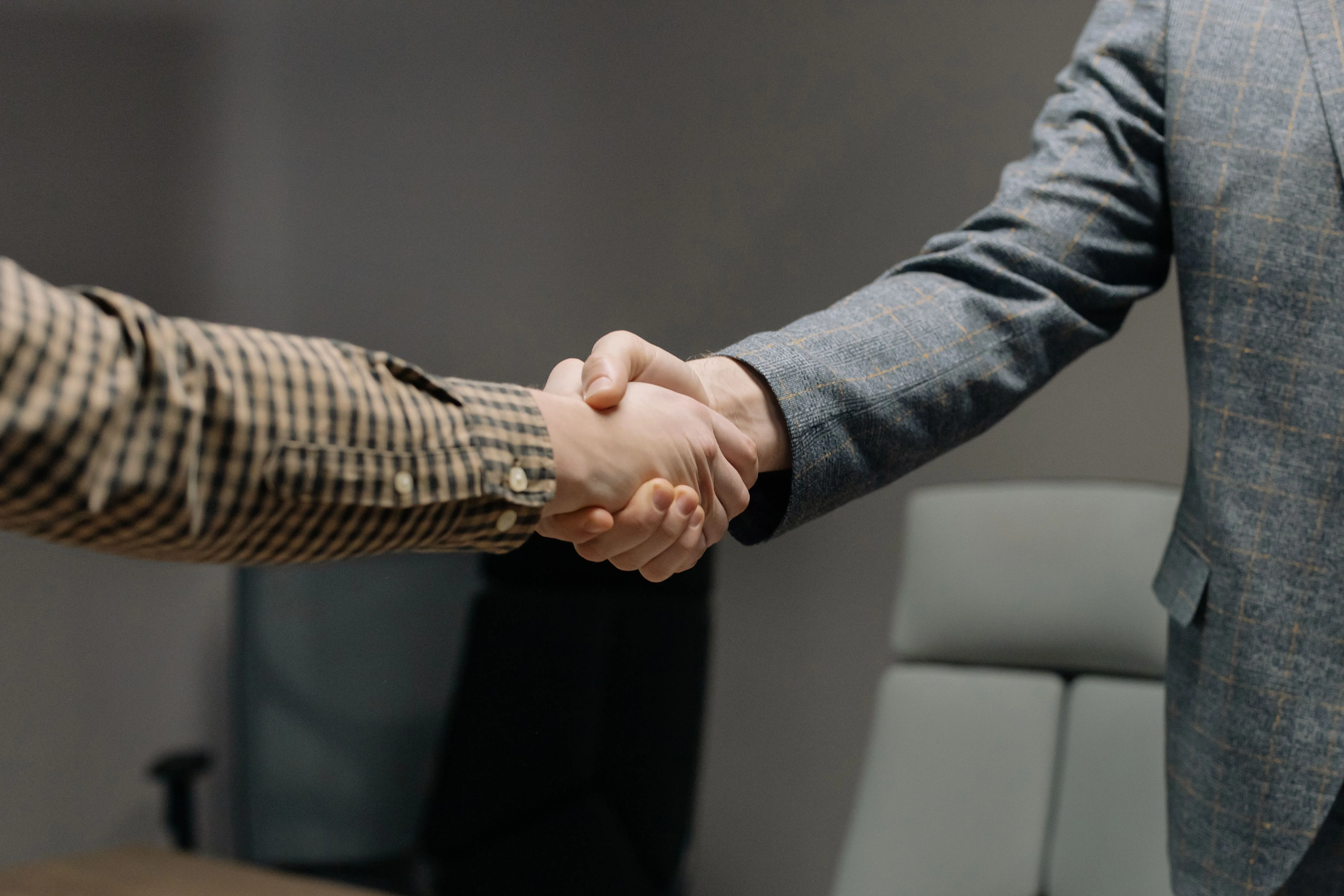Two professionals shaking hands after a job interview — Amazon brand manager hiring in the AI era
